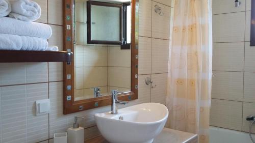 uma casa de banho com lavatório, espelho e toalhas em Old Alleys em Agios Nikolaos