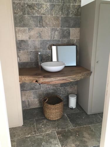 a bathroom with a sink and a mirror on a stone wall at Casa Santa Lucia in Bocognano