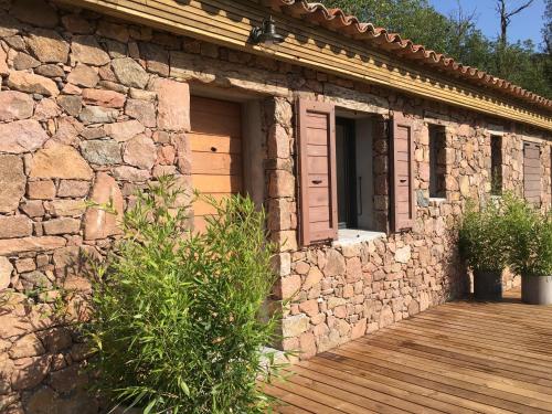 a stone house with a wooden porch and a door at Casa Santa Lucia in Bocognano