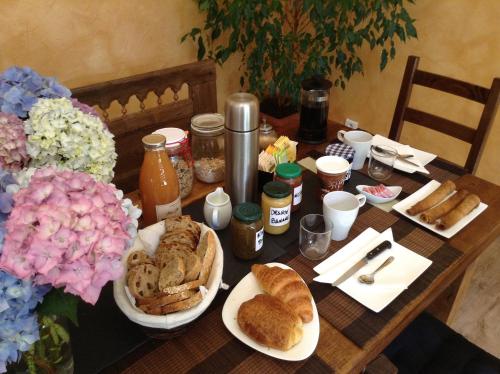 une table garnie d'assiettes de nourriture et de pâtisseries dans l'établissement Loargann Chambres d'hôtes, à Plogastel-Saint-Germain