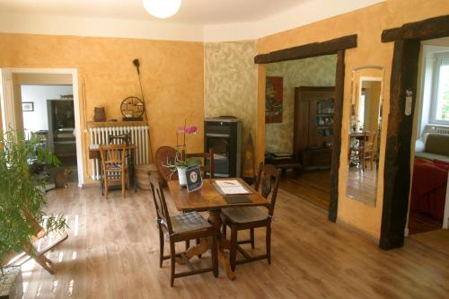 un salon avec une table et des chaises en bois dans l'établissement Loargann Chambres d'hôtes, à Plogastel-Saint-Germain