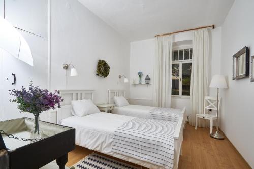 2 letti in una camera bianca con tavolo di Apartment Dundo a Dubrovnik