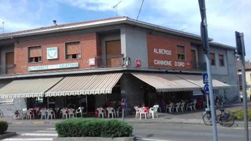 a building with tables and chairs in front of it at Cannone d'Oro in Sale