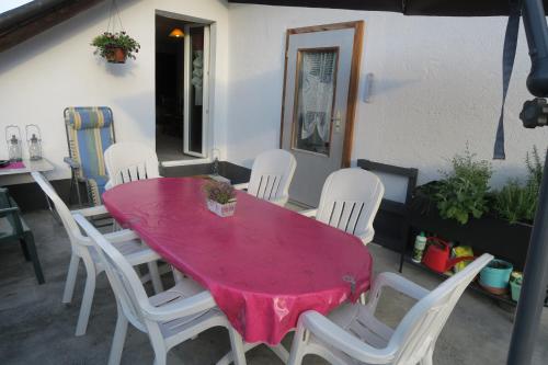 a pink table and white chairs on a patio at L'Union B&B - Chambres d'hôtes in Tramelan