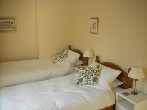 two beds in a small room with two lamps at The Cockatrice B&B in Reedham