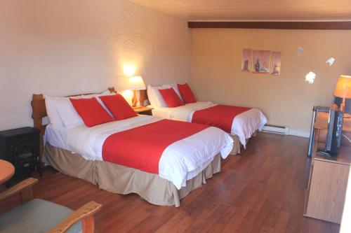 a hotel room with two beds with red pillows at Motel Des Pays D'En Haut in Val-David