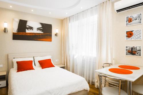 1 dormitorio con cama blanca y mesa en 5days-nn, Studio apartment on Yarmarochnyy Proyezd, 8, en Nizhny Novgorod