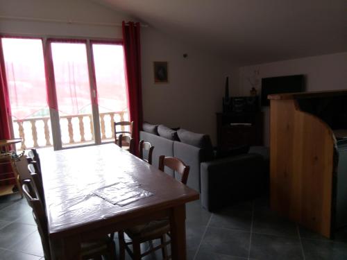 a living room with a table and a couch at Les logis de Lucie in Selonnet