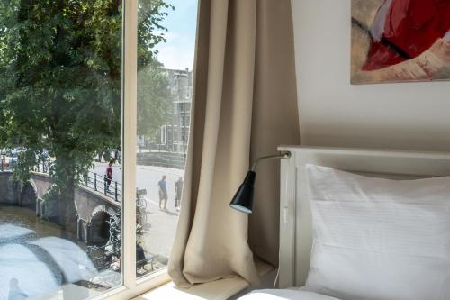 a bedroom with a window with a view of a street at The Blue Stairs in Amsterdam