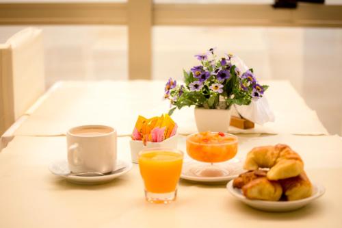 فندق سكاي في سان برناردو: طاولة مع طعام الإفطار وعصير البرتقال والزهور