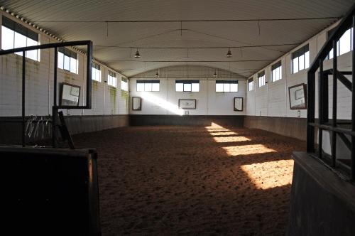 an empty horse barn with sunlight shining through the windows at Sleep In Bucelas in Bucelas