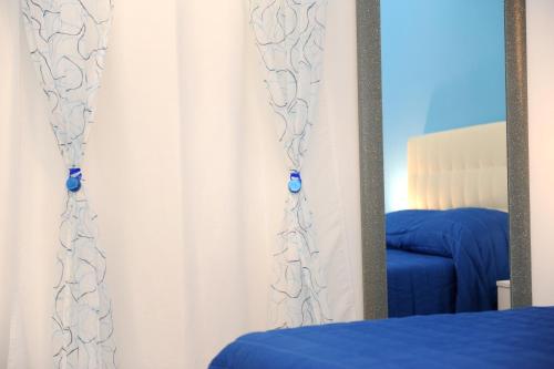 a mirror in a room with a bed and a window at L'Isola Del Postino Rooms in Procida