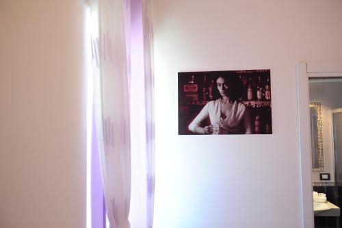 a picture of a woman hanging on a wall at L'Isola Del Postino Rooms in Procida