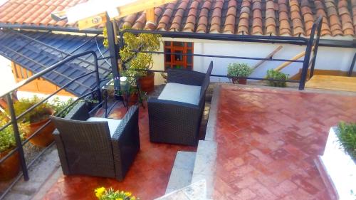 einen Blick über eine Terrasse mit Stühlen und Pflanzen in der Unterkunft Quinua Boutique Apartments in Cusco