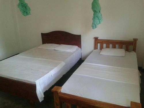 two beds in a room with two beds sidx sidx sidx at Parakum Rest Rooms in Polonnaruwa