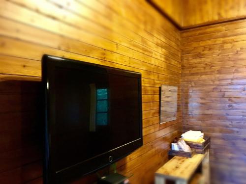 uma televisão de ecrã plano pendurada numa parede de madeira em Wan Ruey Resort em Hengshan