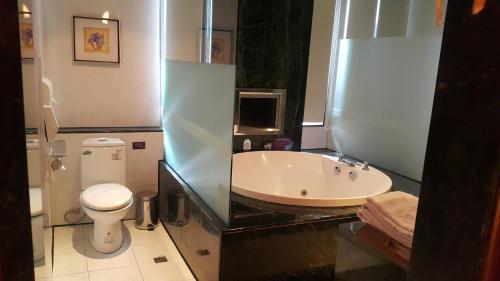 a bathroom with a bath tub and a toilet at 探索汽車旅館中和館 新北市旅館277-2號 in Zhonghe