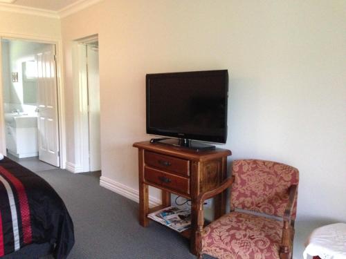 a television sitting on a table with a chair at Goldberryaccommodation in Marysville