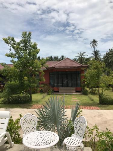 a house with two chairs and a table at Saree Lagoon Villa Koh Samui in Lipa Noi