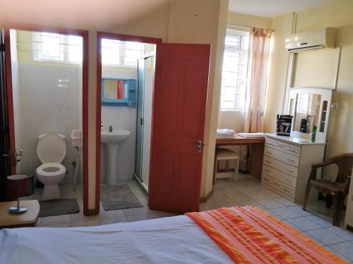 a bedroom with a bathroom with a toilet and a sink at Bayview Villa Seaside in Flic-en-Flac