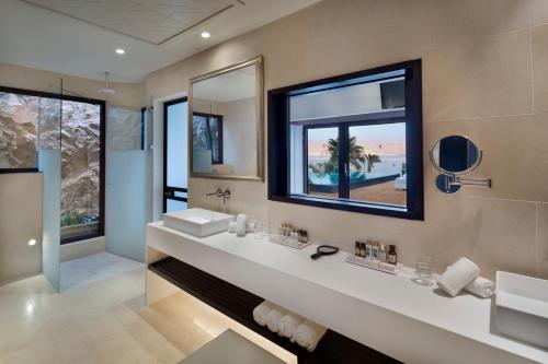 a bathroom with two sinks and a large mirror at Orchid Eilat Hotel in Eilat