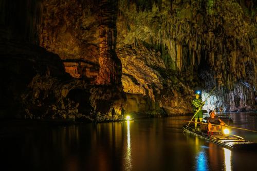 a man in a boat in a cave at Cave Lodge in Pang Mapha