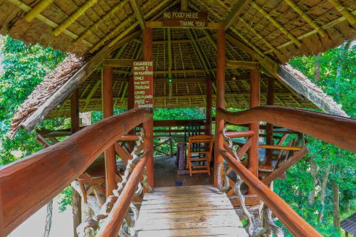 a wooden staircase in a bamboo building with a sign on it at Cave Lodge in Pang Mapha