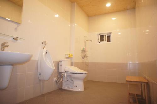 a bathroom with a sink and a toilet and a urinal at Simonhall B&B in Tainan