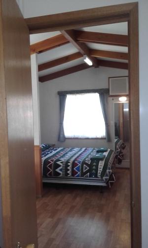 een slaapkamer met een bed en een raam bij Acclaim Gateway Tourist Park in Norseman
