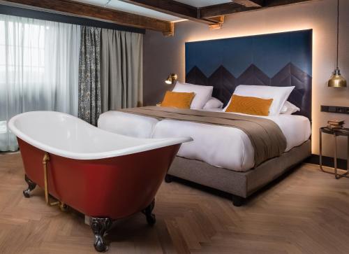 Habitación de hotel con cama y bañera en The Hendrick's Hotel, en Ámsterdam