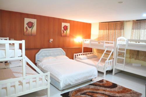 a room with three bunk beds in a room at Zeala Asmara Motel in Kuah