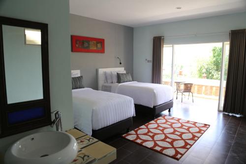 a bedroom with two beds and a sink and a bathroom at Borobudurhills in Borobudur