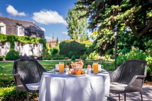a table with a bowl of fruit and orange juice at Le Clos d'Amboise in Amboise