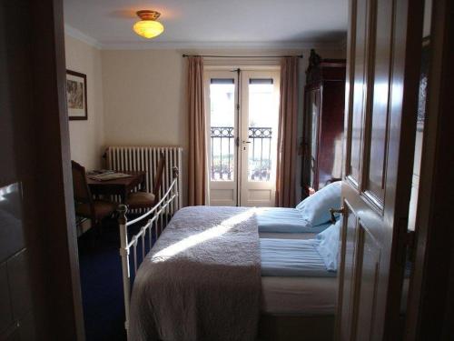 a small bedroom with a bed and a window at Logement Brocante in De Koog