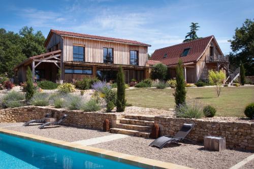 une maison avec une piscine en face de celle-ci dans l'établissement Le Lion D'Or en PERIGORD, à Mauzac-et-Grand-Castang