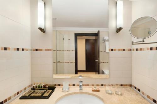 uma casa de banho com um lavatório e um espelho em Ramada Plaza by Wyndham Gevgelija em Gevgelija