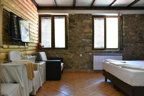 a room with two beds and a couch and windows at Canyon Matka Hotel in Matka