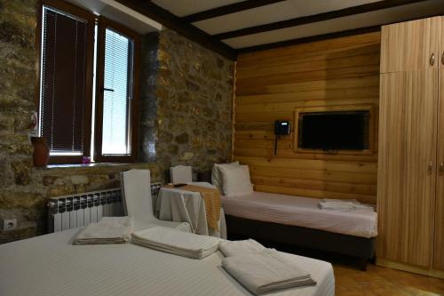 a room with two beds and a tv in it at Canyon Matka Hotel in Matka