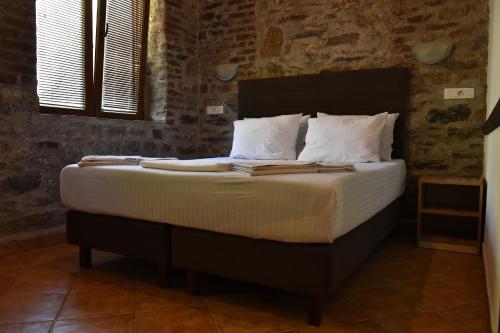 a bed with white sheets and pillows in a room at Canyon Matka Hotel in Matka