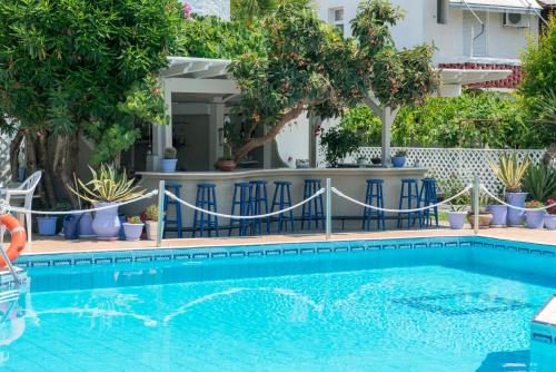 a swimming pool in a yard with trees and plants at Hotel George in Limenas
