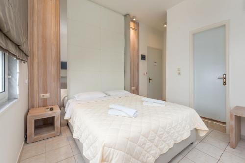 a bedroom with a bed with two towels on it at Hotel George in Limenas