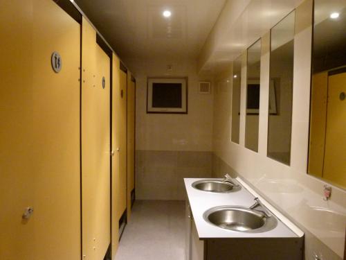 a bathroom with two sinks and two mirrors at Why Me Eco-friendly Hostel in Tbilisi City