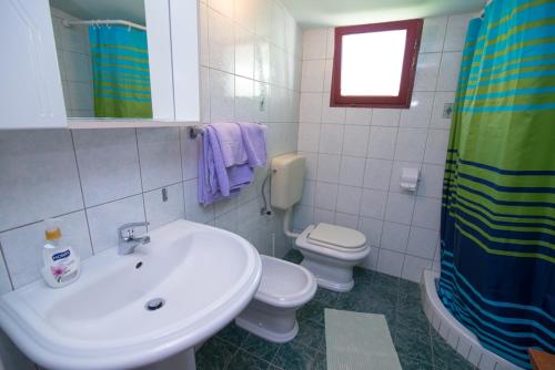 a bathroom with a sink and a toilet and a window at Darko in Veli Lošinj