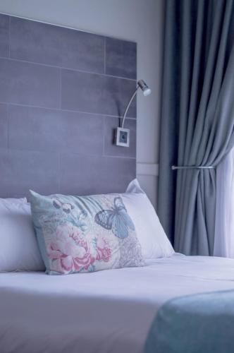 a bed with a pillow and a lamp in a room at 314 on Clark Guest House in Pretoria