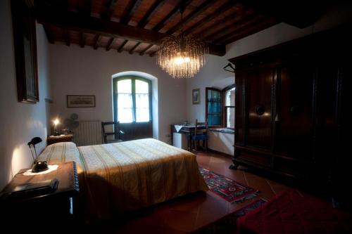 a bedroom with a large bed and a chandelier at Agriturismo La Grotta in San Giuliano Terme