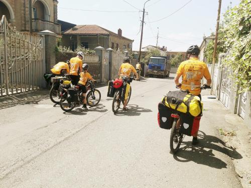a group of people riding bikes down a street at Medico and Suliko Guest House in Kutaisi