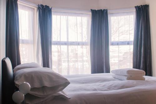 a bedroom with a bed with blue curtains and a window at Wellesley Park Hotel in Great Yarmouth