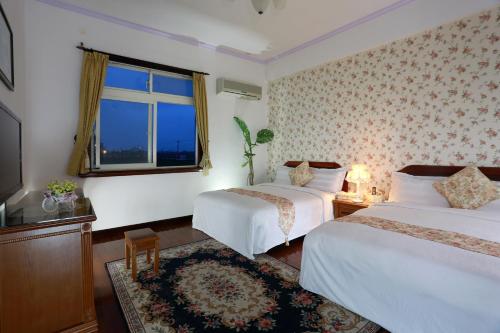 五結鄉的住宿－黃金屋渡假民宿，酒店客房设有两张床和窗户。