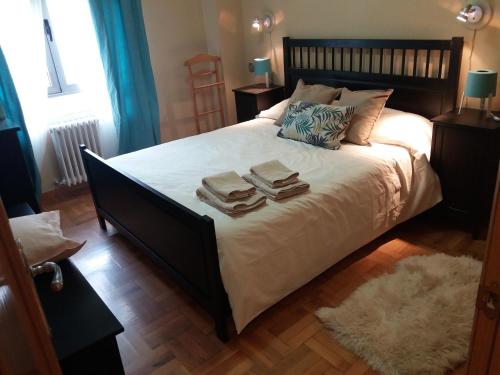 a bedroom with a large bed with two books on it at Apartamento Pleno Centro Gran Via in Logroño