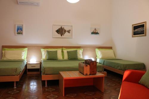 a room with two beds and a table with a suitcase at Casa Noemi b&b in Uggiano la Chiesa